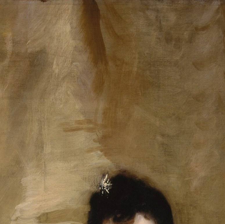 The high, pinned hairstyle dates the portrait precisely to the early 1890s fashion moment; contrasts sharply against the warm gold drapery behind.