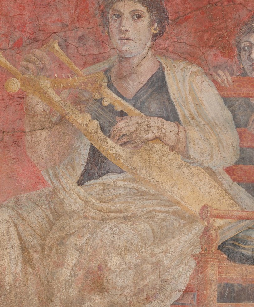 The large, ornate stringed instrument is the compositional center; its golden color and scale suggest a ceremonial rather than everyday object, linking the scene to Apollo or the Muses.