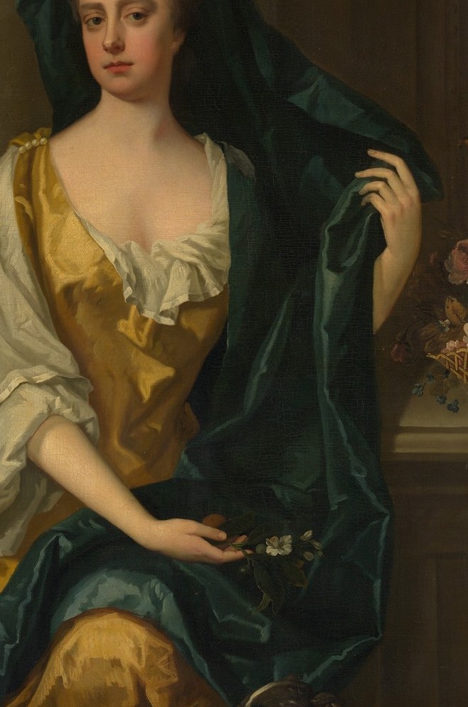 The green shawl drapes dramatically, adding rich contrast.