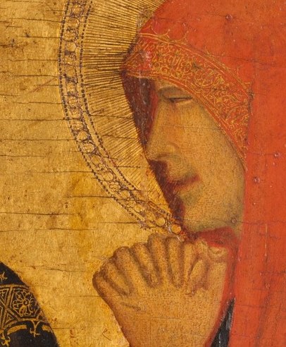Her hand lifts to her chin. The ancient sign of grief.