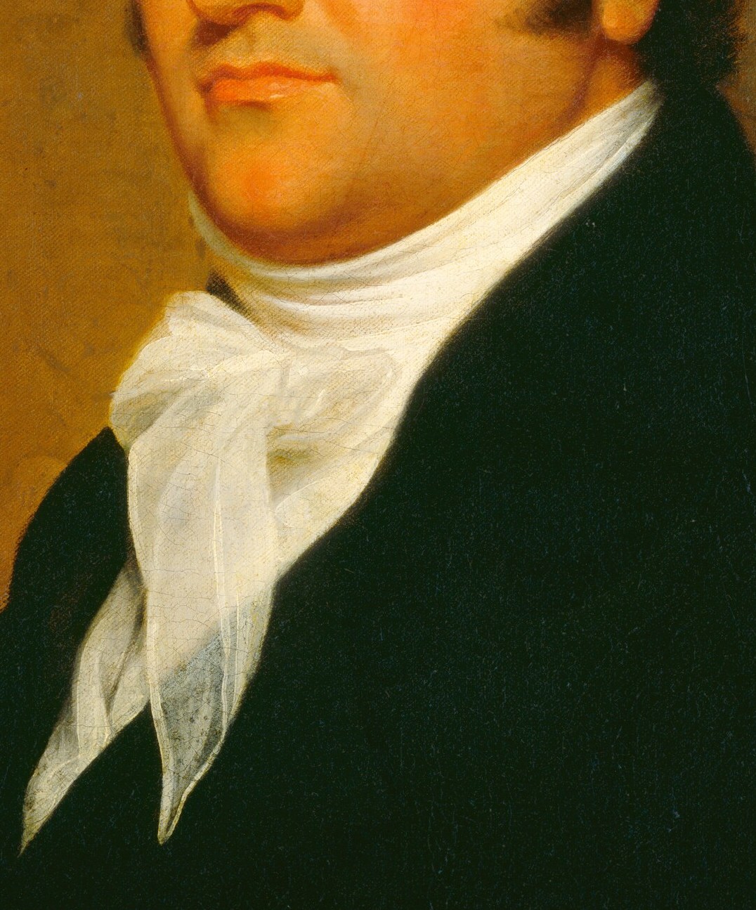 The crisp white fabric contrasts with his dark coat, drawing attention to his face and neck.