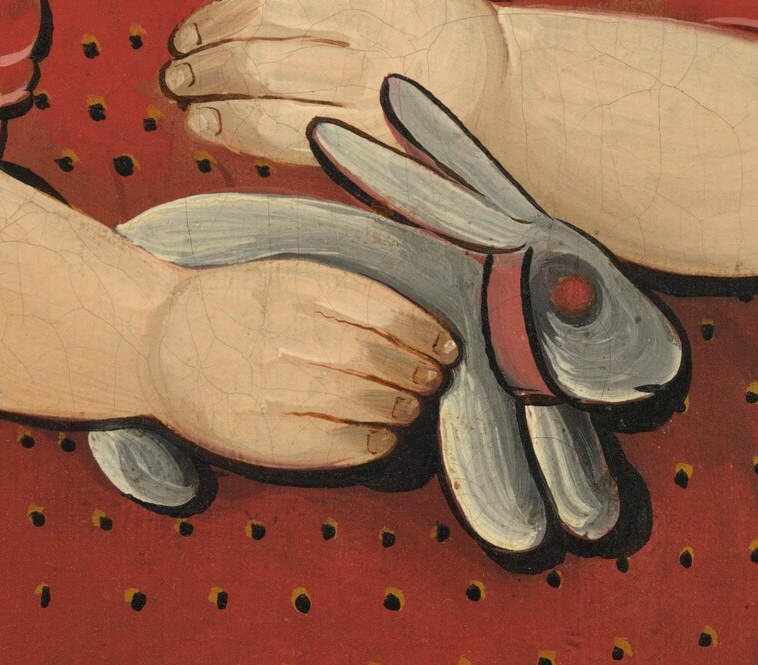 The little girl holds a toy rabbit, a simple childhood comfort.