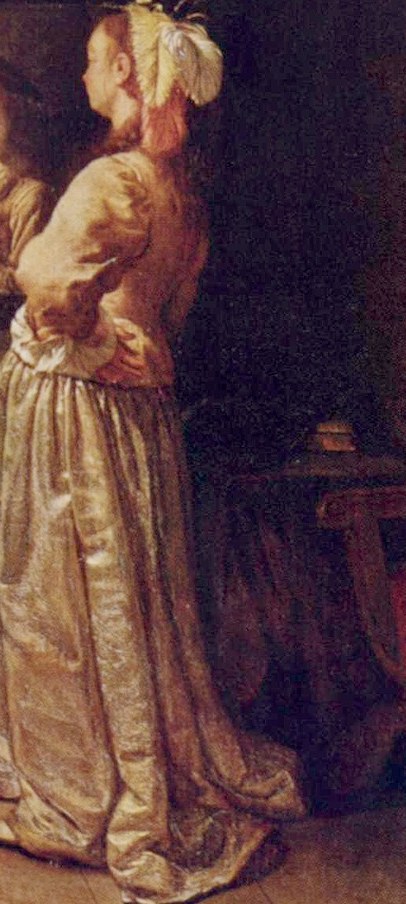 The woman looks at herself in an ornate mirror.