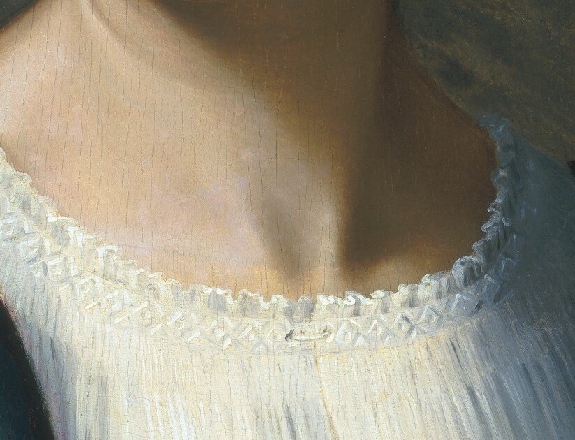 She wears a delicate lace collar and braided hair.