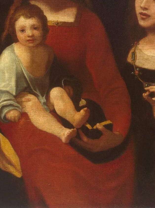 The rich, deep red fabric drapes elegantly, symbolizing her role as Queen of Heaven and her maternal love.