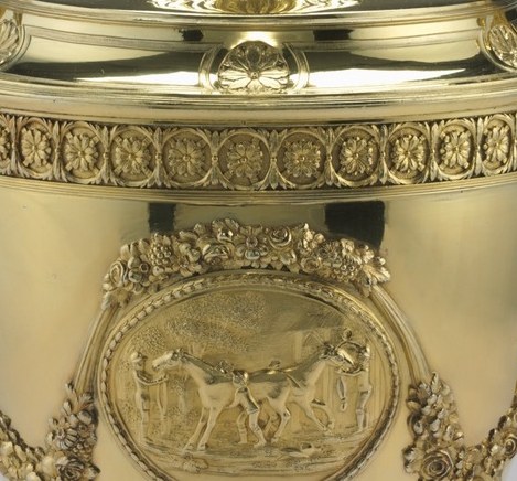 The central medallion shows horses and a chariot.