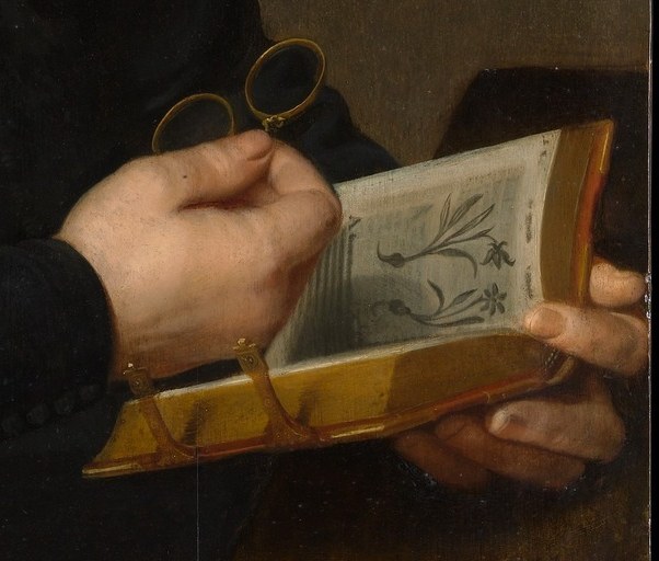 He holds spectacles and a book of botanical drawings.