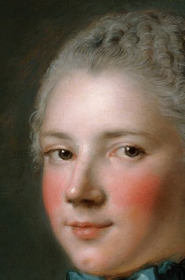 Her direct gaze and rosy cheeks convey a sense of youthful innocence and perhaps a touch of coyness.