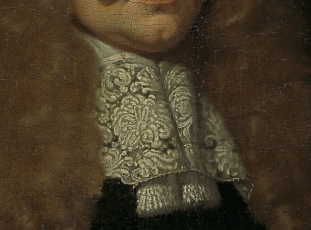 The intricate lace and fine detail of the cravat signify wealth, status, and adherence to contemporary fashion.