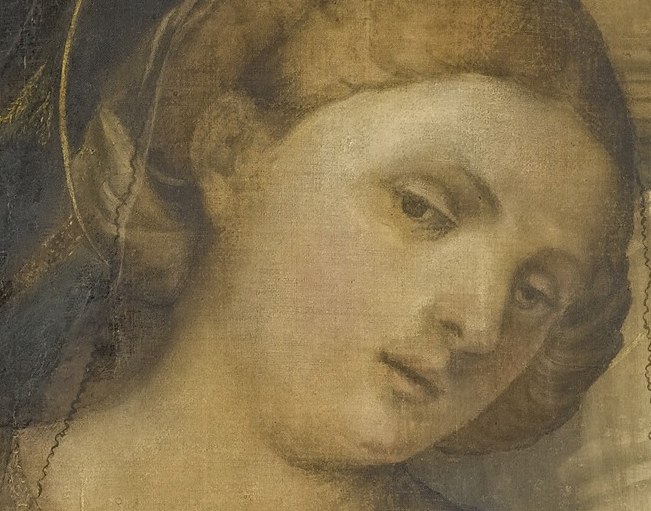 She looks directly at you, holding her child.