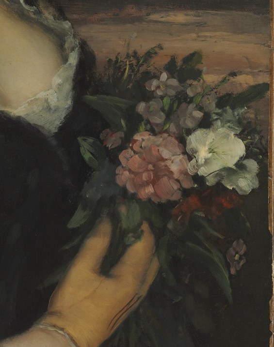 The vibrant colors of the flowers offer a touch of life and beauty against the darker tones of her clothing.