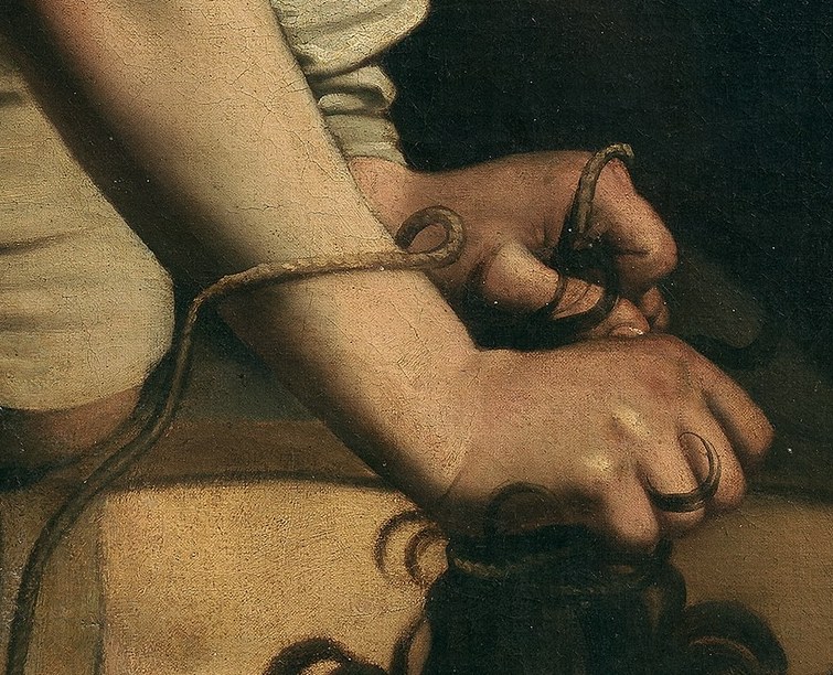 He holds Goliath's hair with a firm grip.