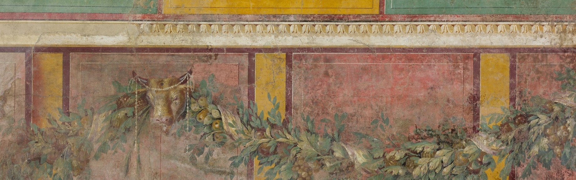 The garland is the visual spine of the entire composition; a slow tracking shot along its length would read as an inventory of Dionysiac and seasonal abundance , grapes, pomegranates, pine cones, wheat , each carrying symbolic weight.
