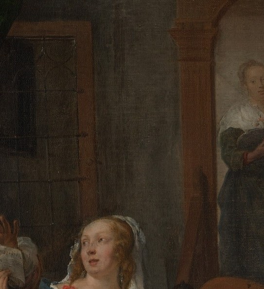 Her downward gaze and slightly open mouth signal concentration or speech; close-up reveals what she is responding to.