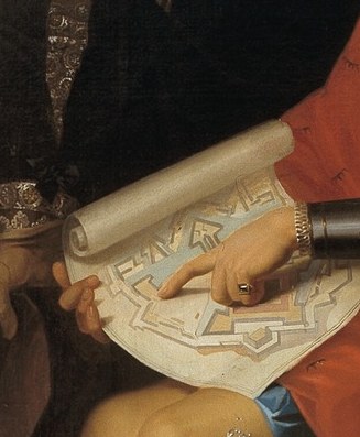 His gesture highlights the detailed plans for the fortress.