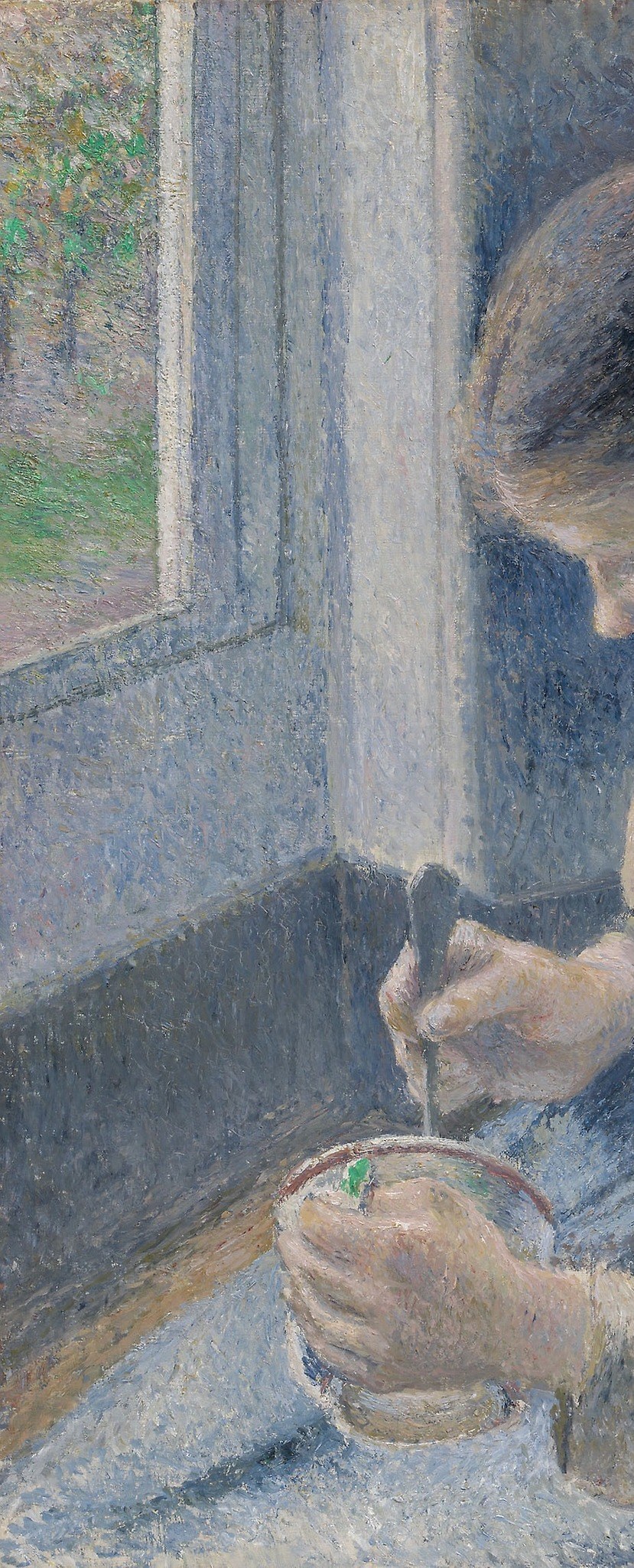 She sits by a window, lost in thought.