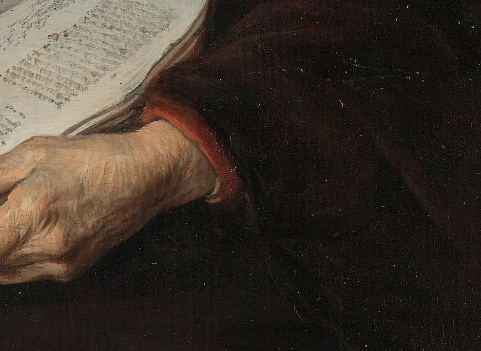 Her hands carefully hold an open book and glasses.