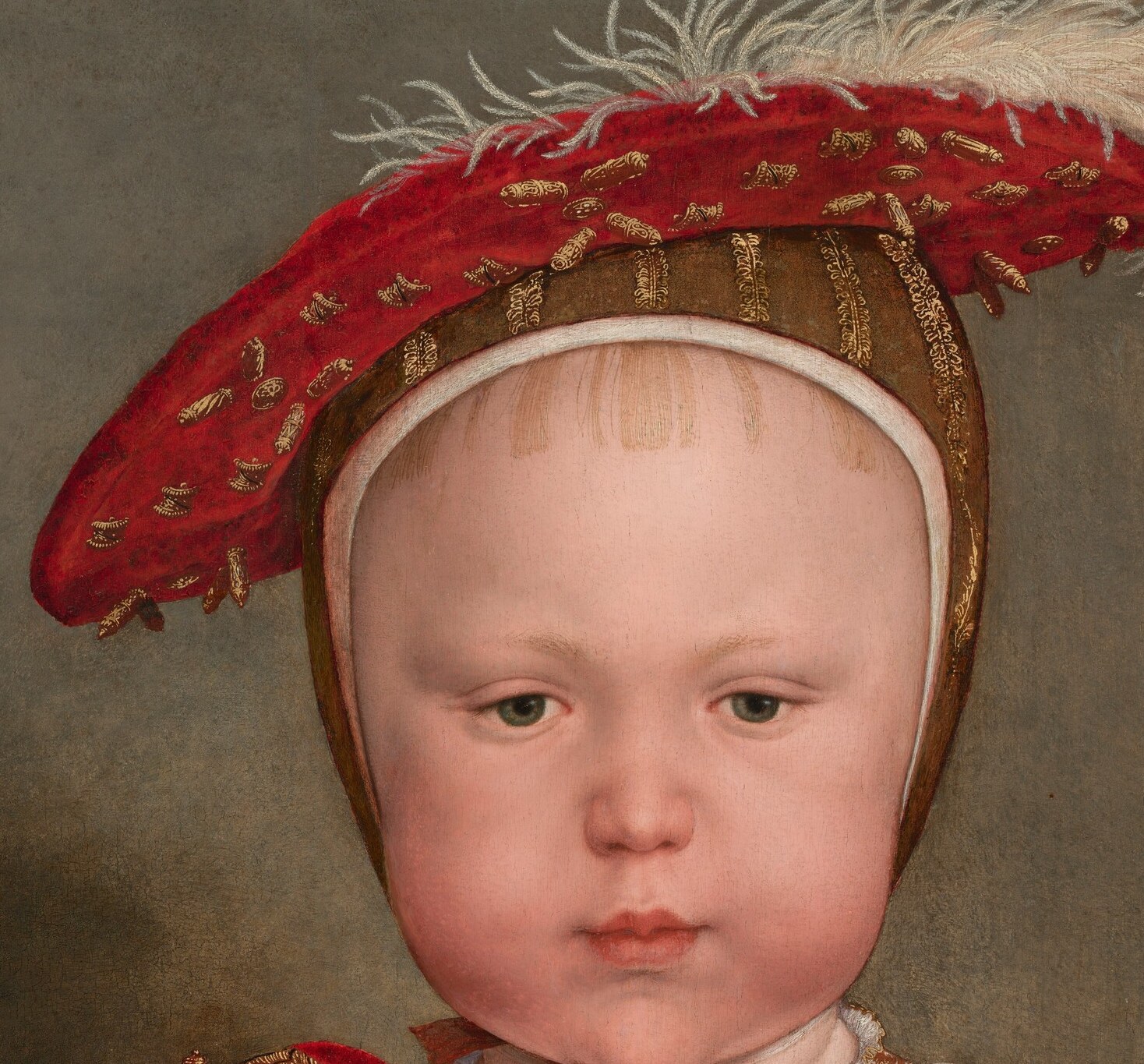 He wears the face of a one-year-old and the clothes of a king.