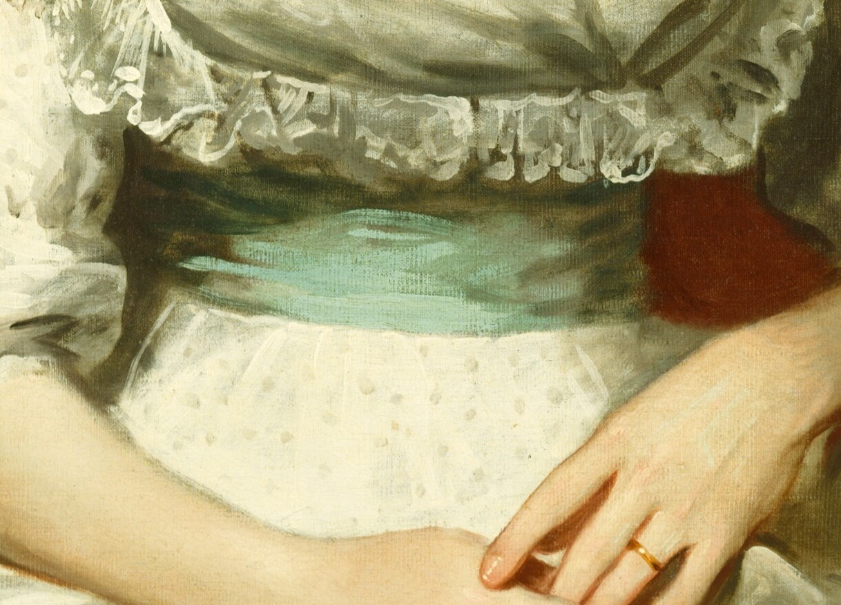 Her hands rest folded in her lap. Composed, still.