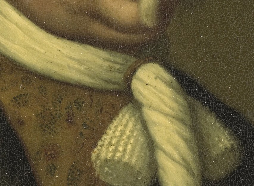 Look closely at his chest, below the cravat.