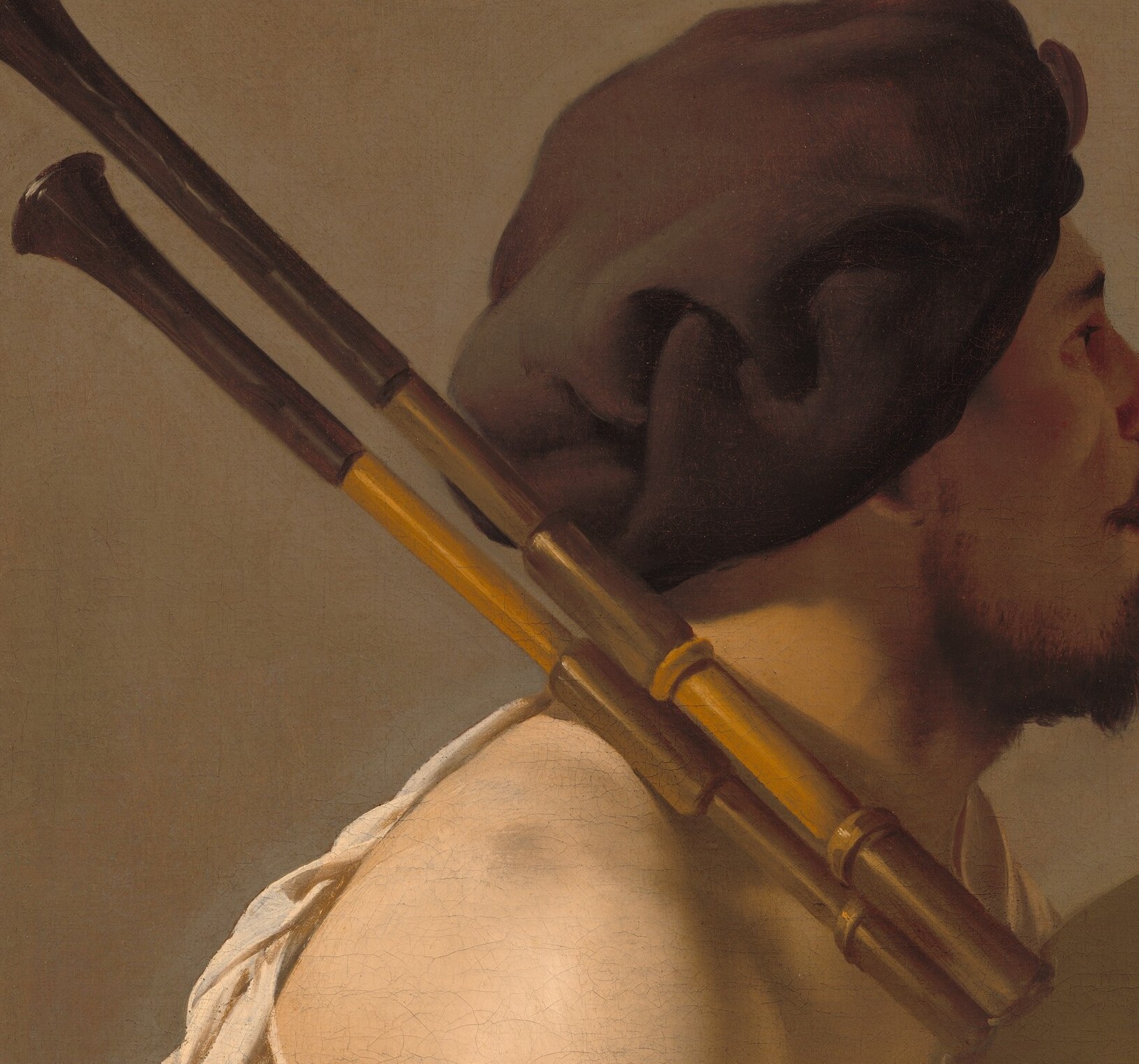 Look at the instrument's drone pipes, resting on his shoulder.