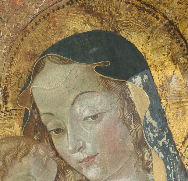 She looks down at her child with a quiet, steady gaze.