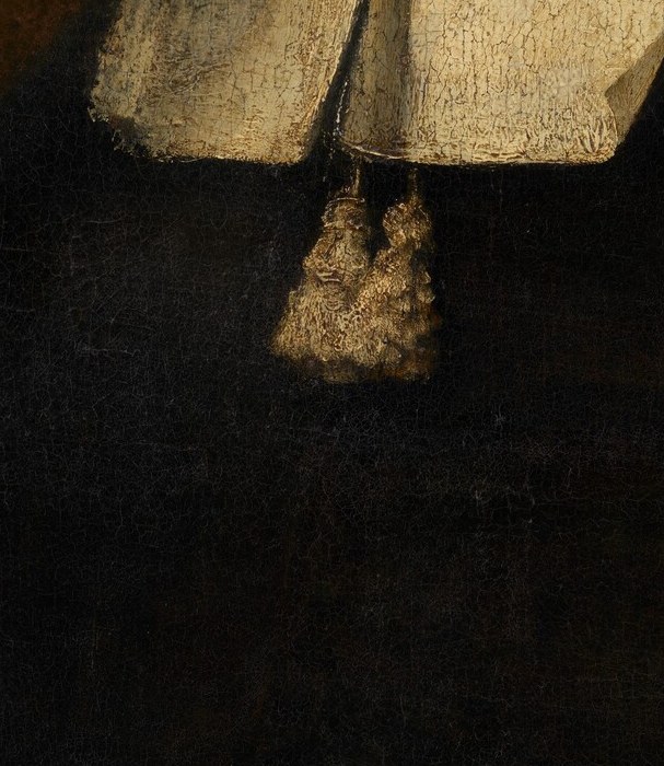 A glint of gold beneath the collar. A chain of office, perhaps.