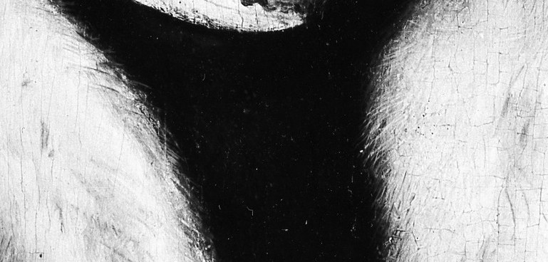 A gold chain glints at the collar's opening.