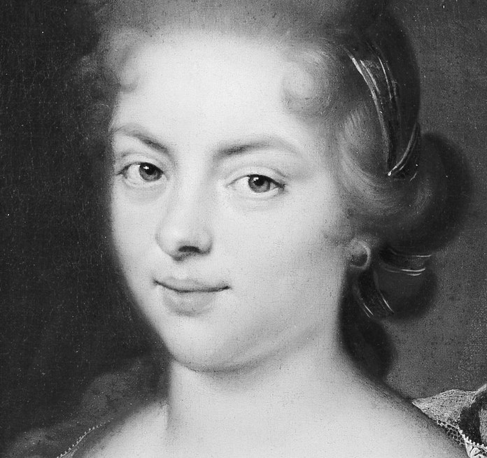 Her direct gaze and subtle smile convey a sense of composure and perhaps a hint of inner thought.