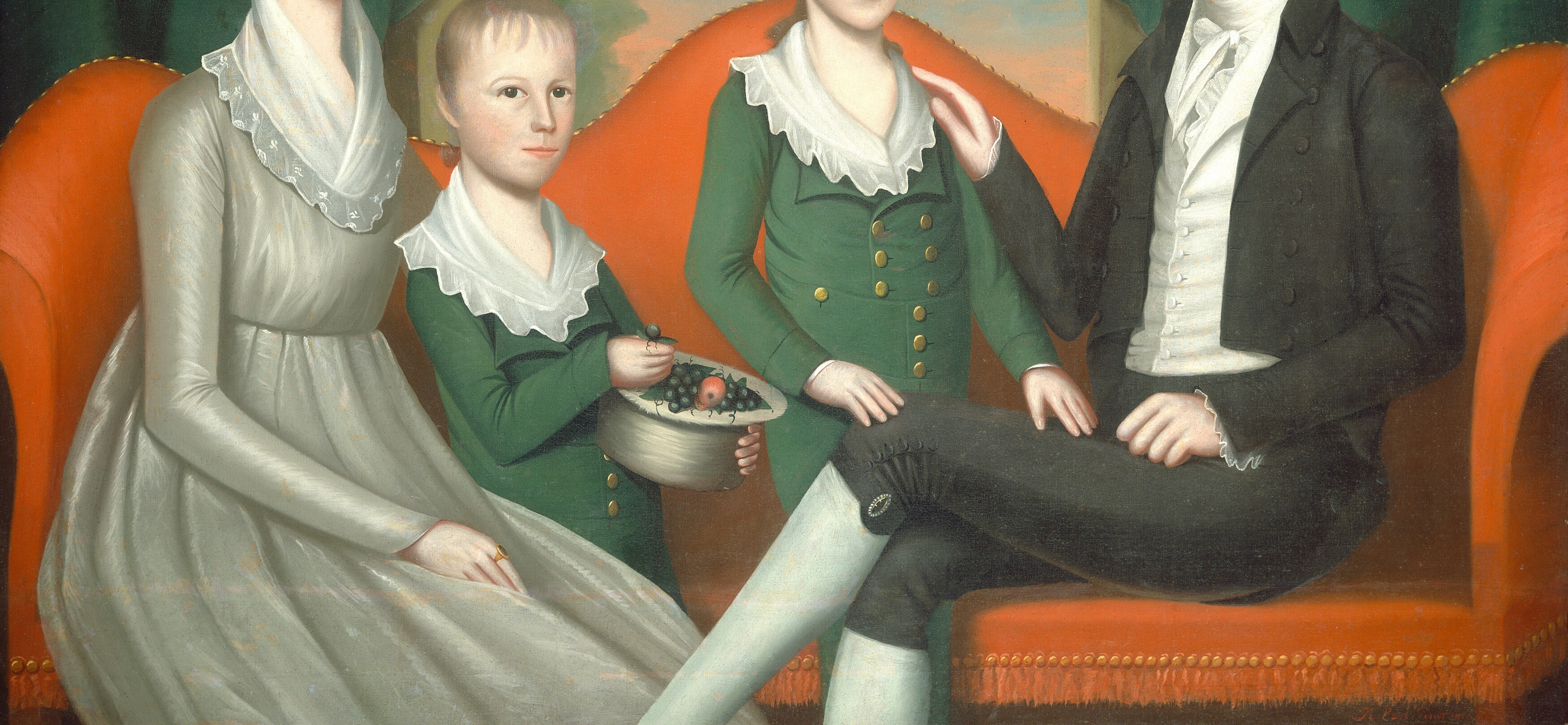 The orange couch creates a warm, inviting setting for the family.