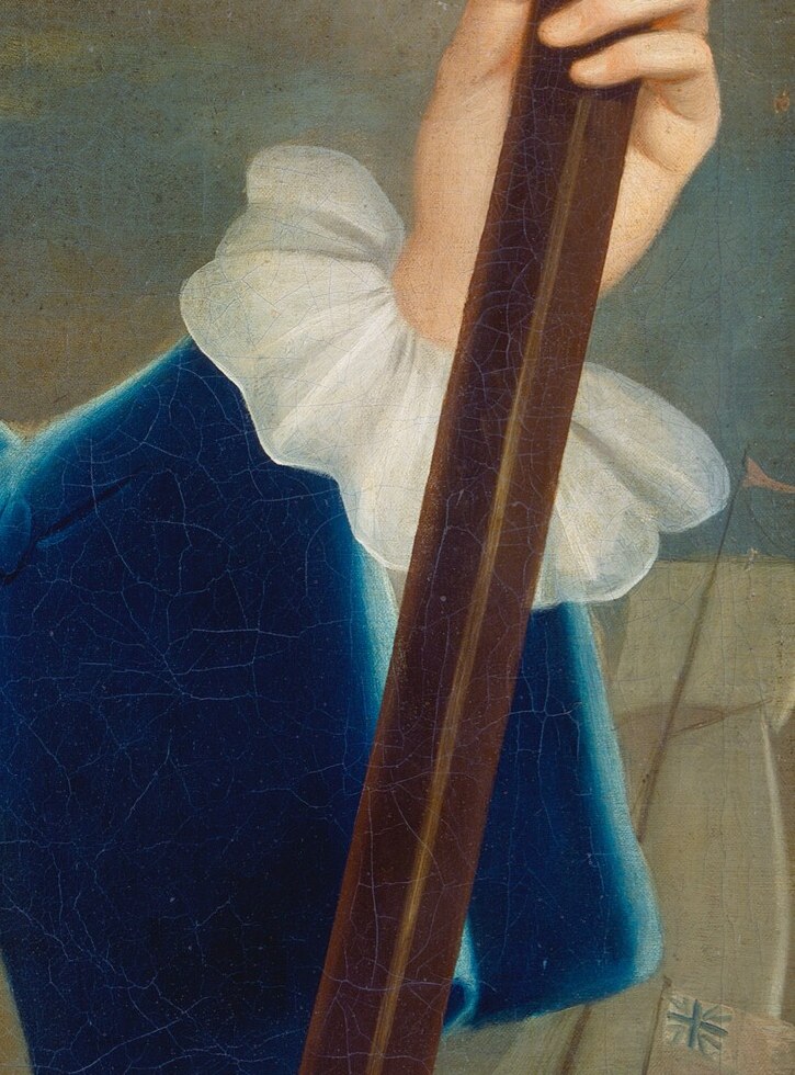 Beyond his arm, tiny ships hint at his profession.