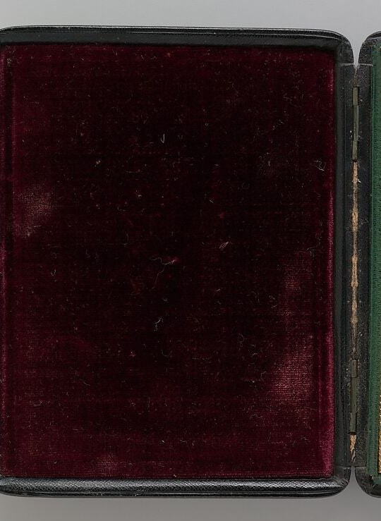The plush velvet suggests the case was a luxurious item, protecting a valuable keepsake.