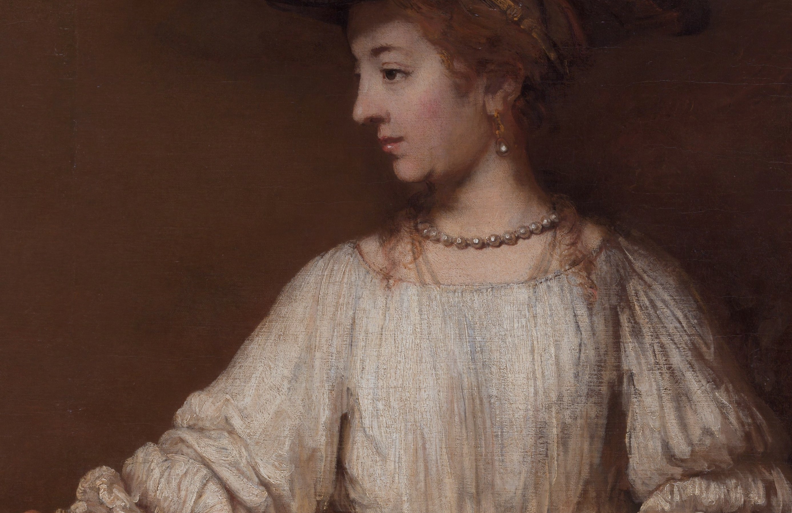 The dominant area of the canvas; Rembrandt's impasto is most extravagant here , paint applied in thick ridges that physically catch the light, making fabric texture tactile.