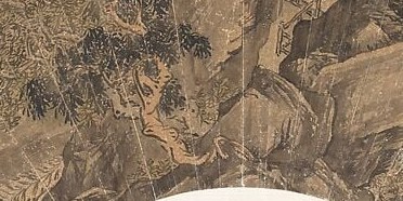 Two figures sit inside, watching the water fall.
