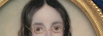 Round spectacles. Almost never seen on women in 1840s portraiture.
