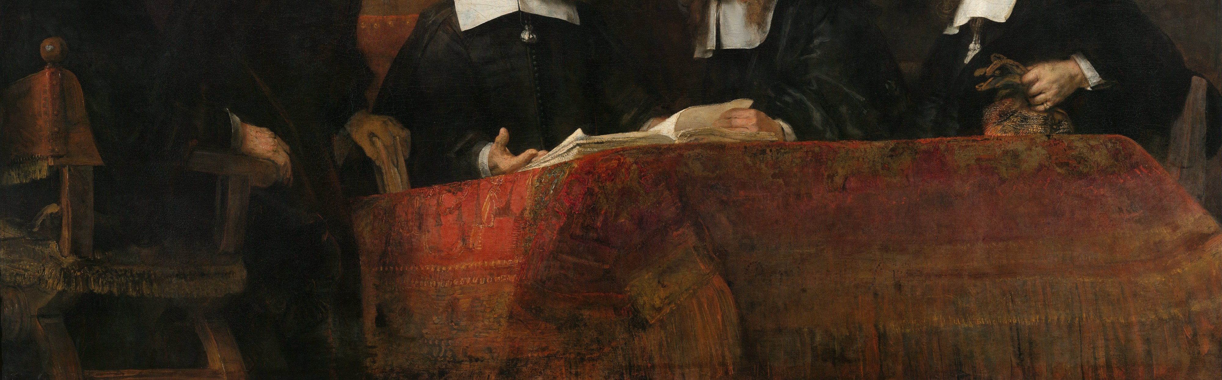 The single saturated color in an otherwise near-monochromatic palette. Rembrandt uses it as visual anchor and status marker , only officers of standing convene at a table this formally dressed.