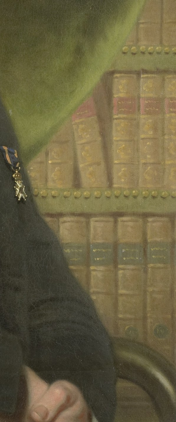 His background, a bookshelf, suggests an intellectual man.