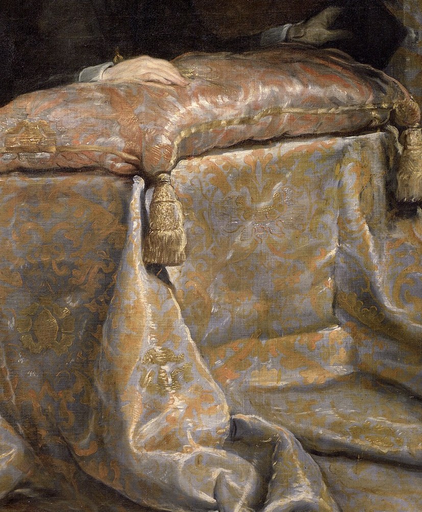 The rich fabric and plush padding suggest comfort and status, even in a devotional setting.