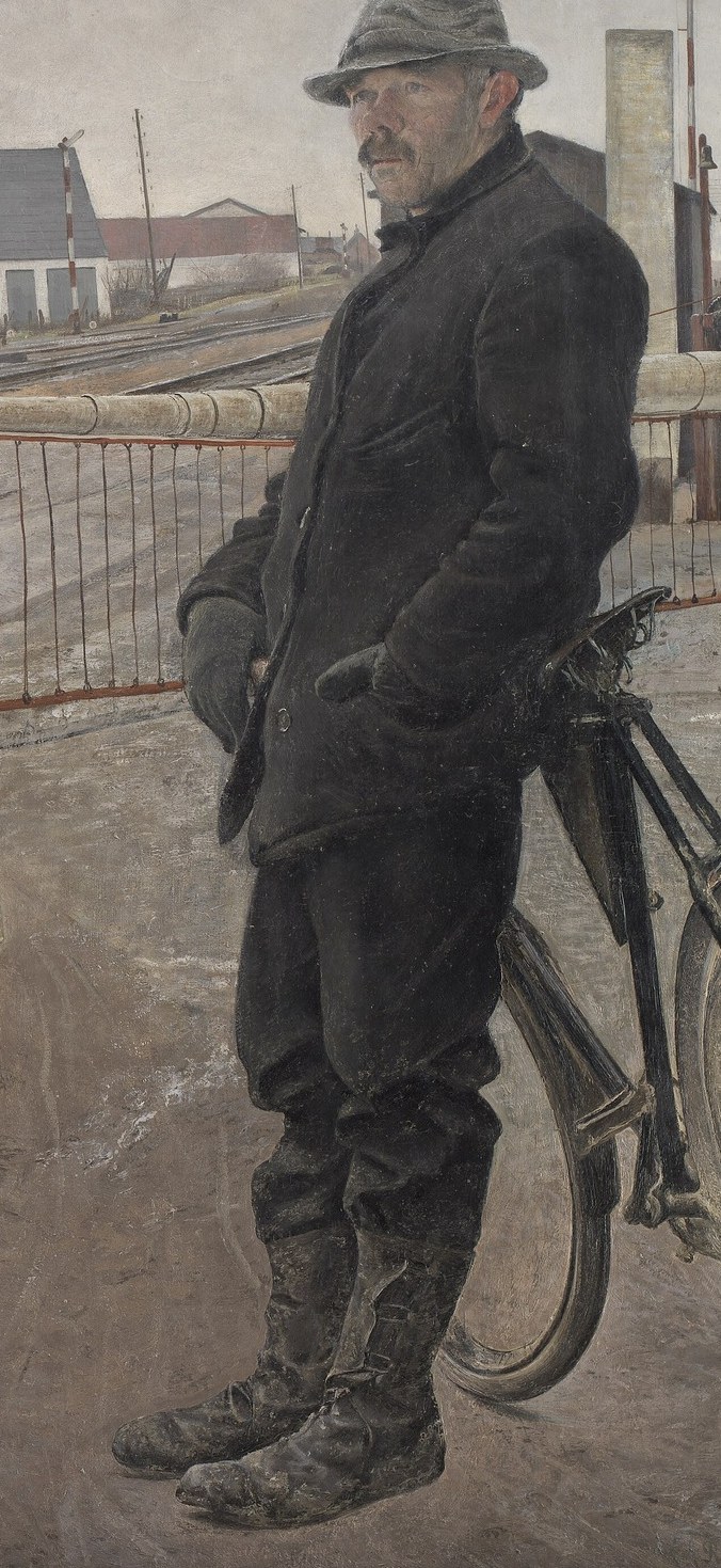 This man is waiting at the train crossing.