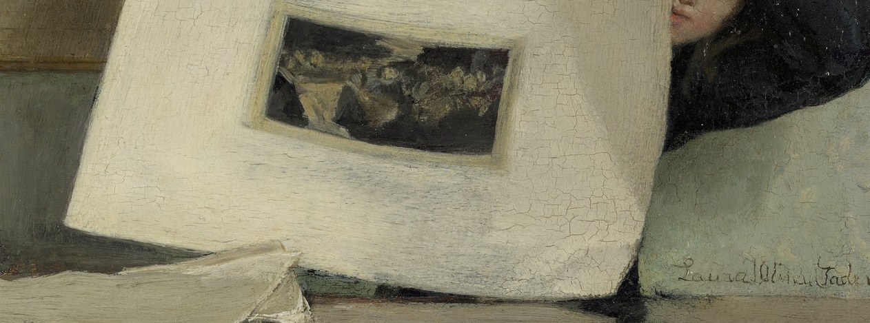 The woman holds a print up to the light.
