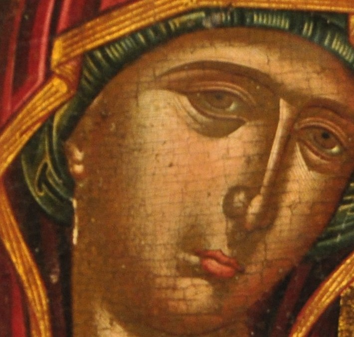 The deep red of the veil, a traditional color for Mary, adds a regal and maternal quality.