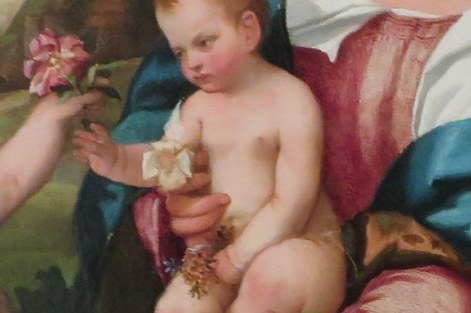 The Christ Child reaches for a flower, a symbol of purity.