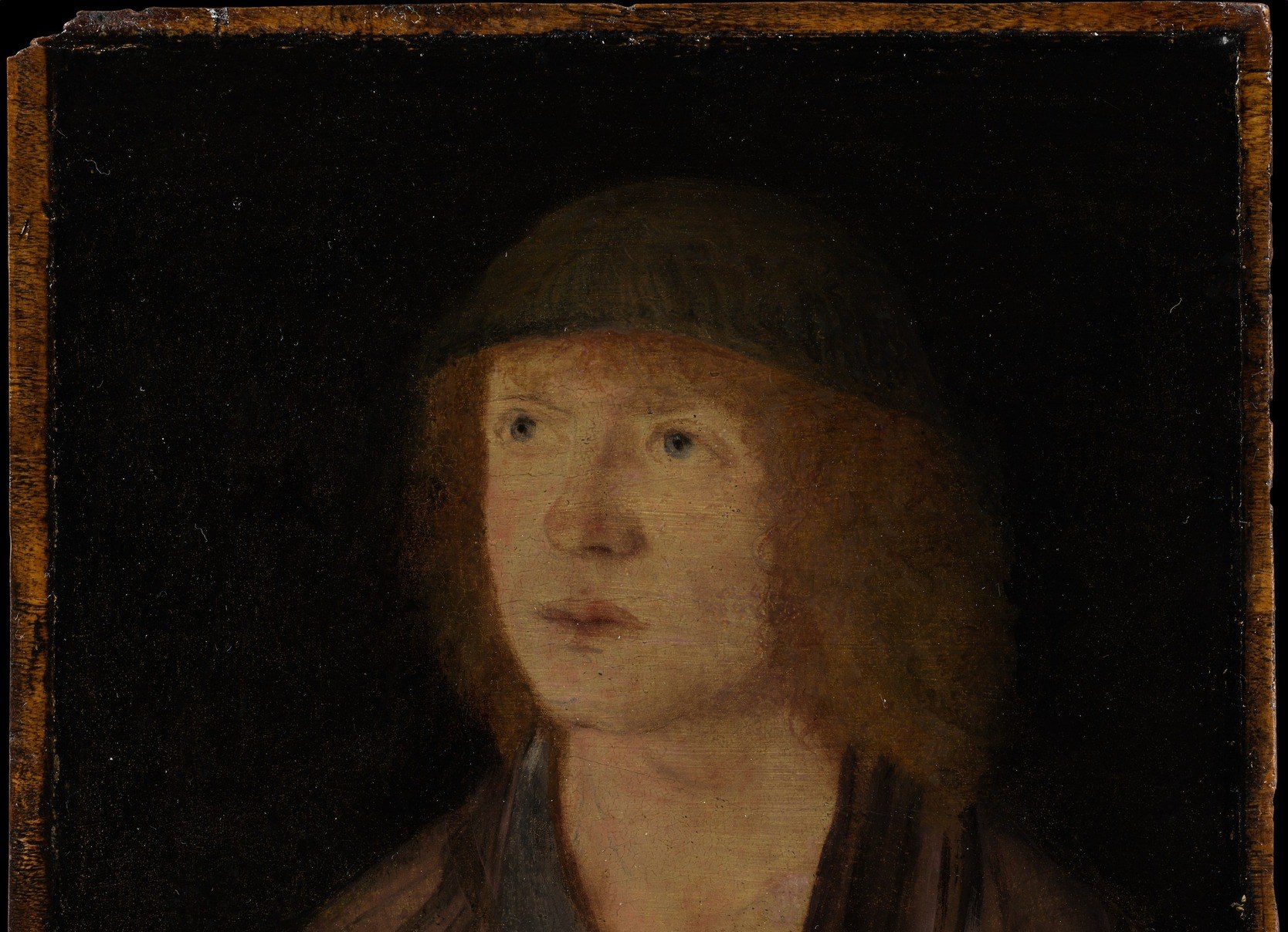 The near-black ground is a deliberate Flemish-influenced choice: no setting, no props, no distraction , the whole painting becomes a study in one person's interiority