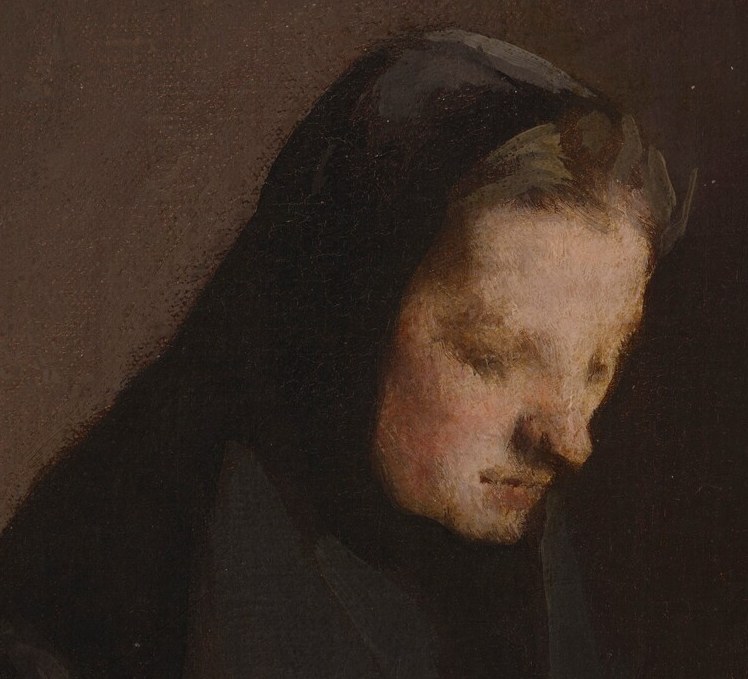 A woman sits alone, absorbed in mending.