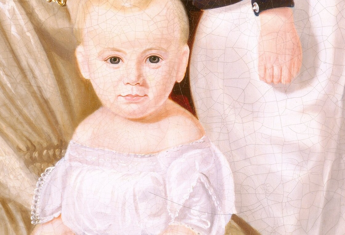 Her hands tenderly cradle the infant, a universal gesture.