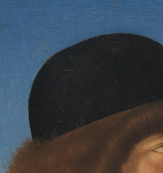 The dark, rounded shape of the hat frames his face and adds a sense of gravitas.