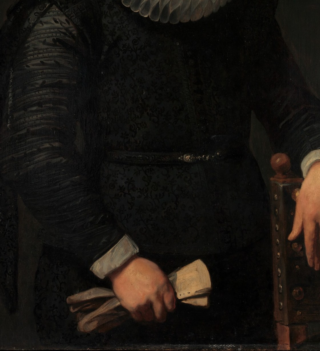 The near-featureless black cloth is technically demanding , Van Dyck distinguishes it from the background only by subtle reflected edge light, a virtuoso exercise in near-black differentiation.