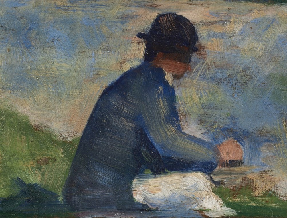 This man in blue sits on the grassy bank, perhaps fishing.