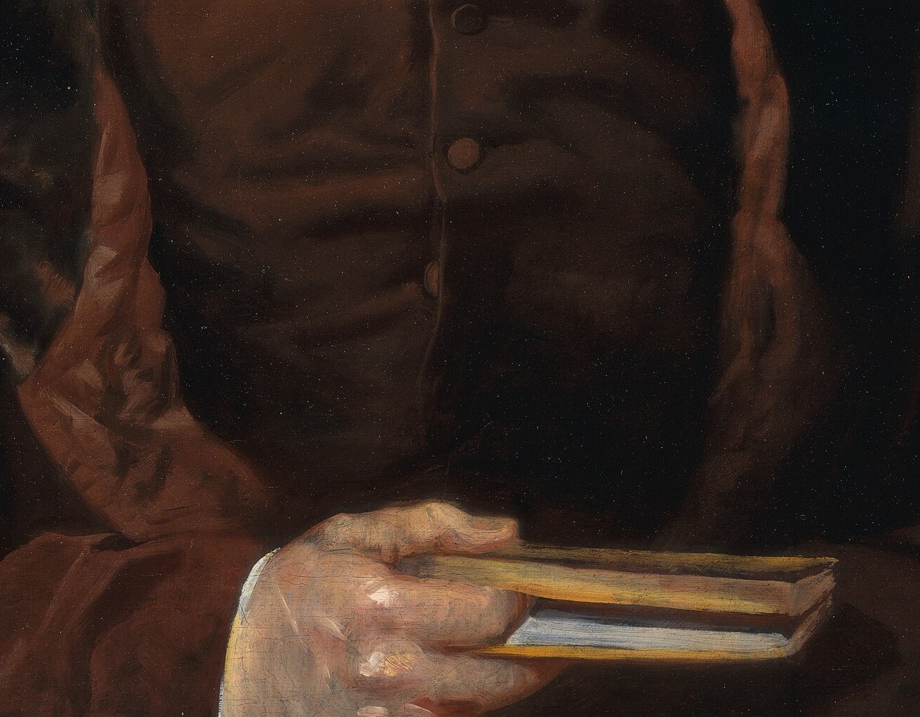 Look at what he's holding: a small book or document.