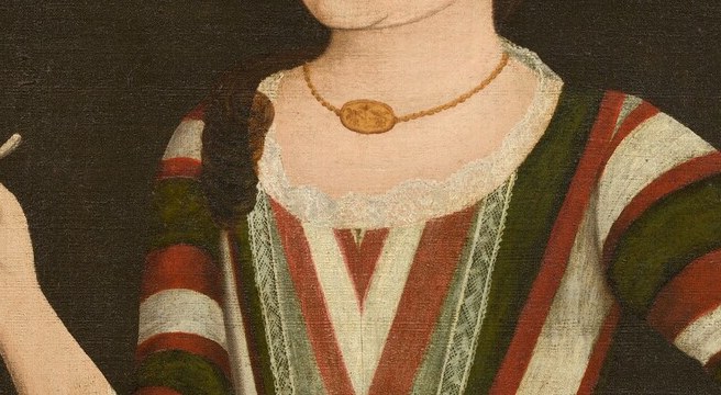 Coral was worn by Dutch-American children as a protective amulet against illness; its presence here is a cultural and social-status marker specific to Hudson Valley Dutch families.